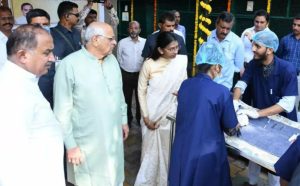 A man in a suit stands at the center, surrounded by a group, featuring Gujarat's CM Shree Bhupendra Patel at the Shree Danev Foundation.