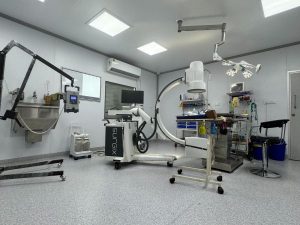 Interior of a medical room with essential equipment and a chair, located in the Shree Danev Foundation Animal Hospital.