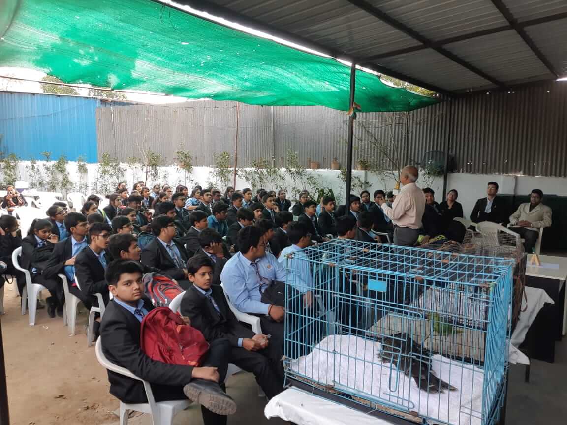 Attendees at the Shree Danev Foundation Awareness Program, sitting in chairs beside a birdcage.